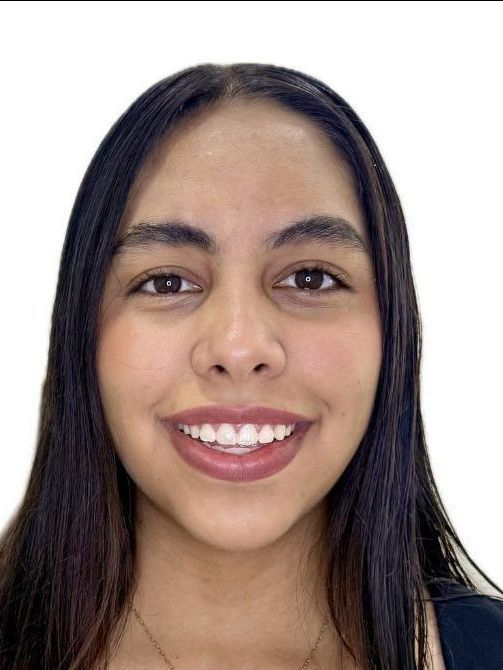 Mujer sonriente con cabello largo y oscuro sobre un fondo blanco liso.