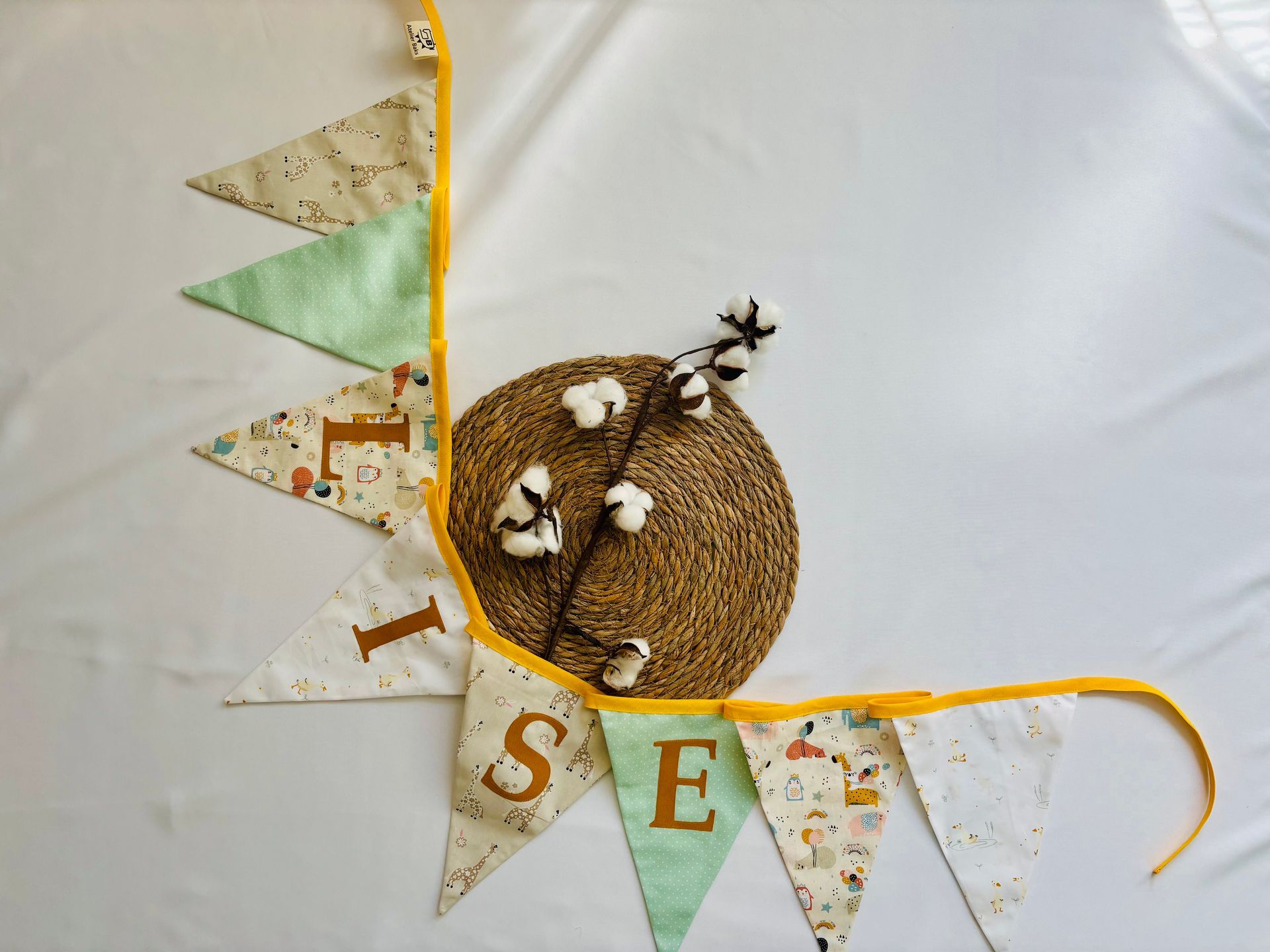 Decoratieve witte banner met geborduurde vlaggetjes en een strokrans op een witte achtergrond.
