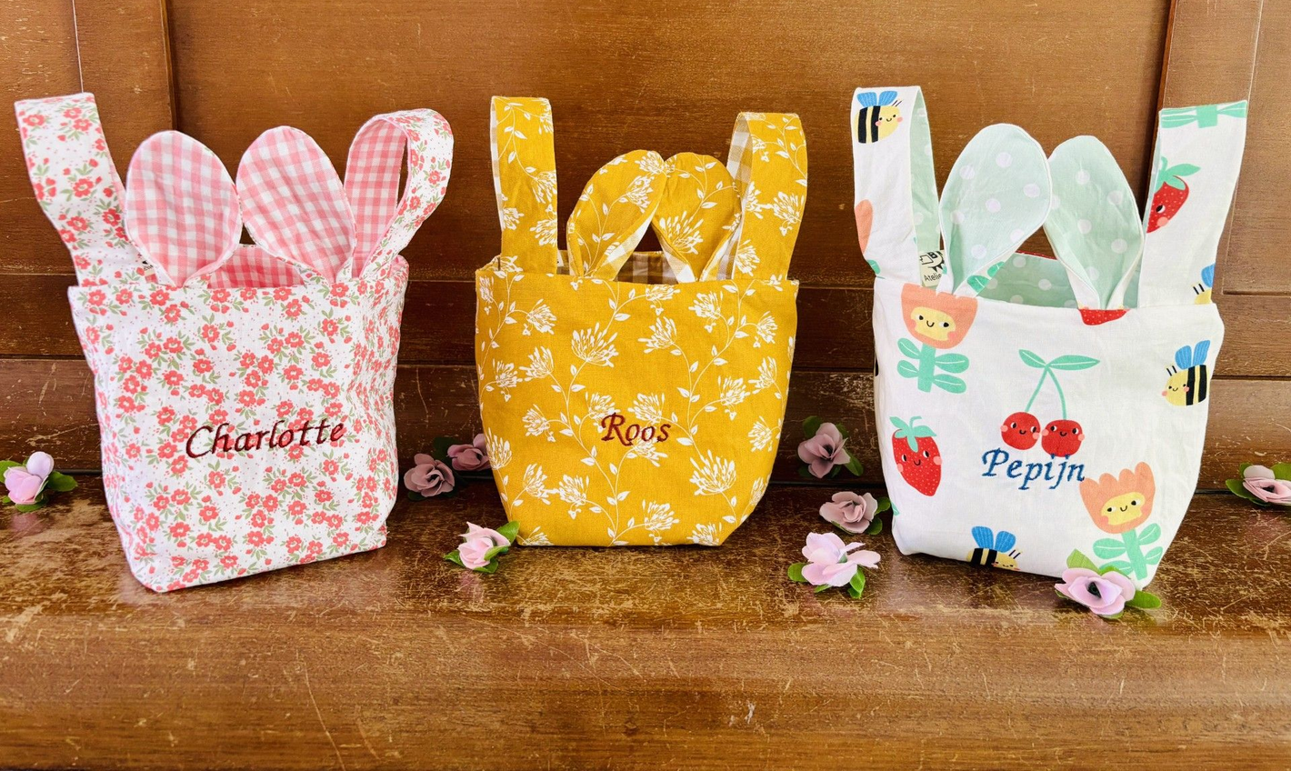 3 paasmandjes in verschillende kleuren naast elkaar, 2 hengsels en 2 oortjes.
