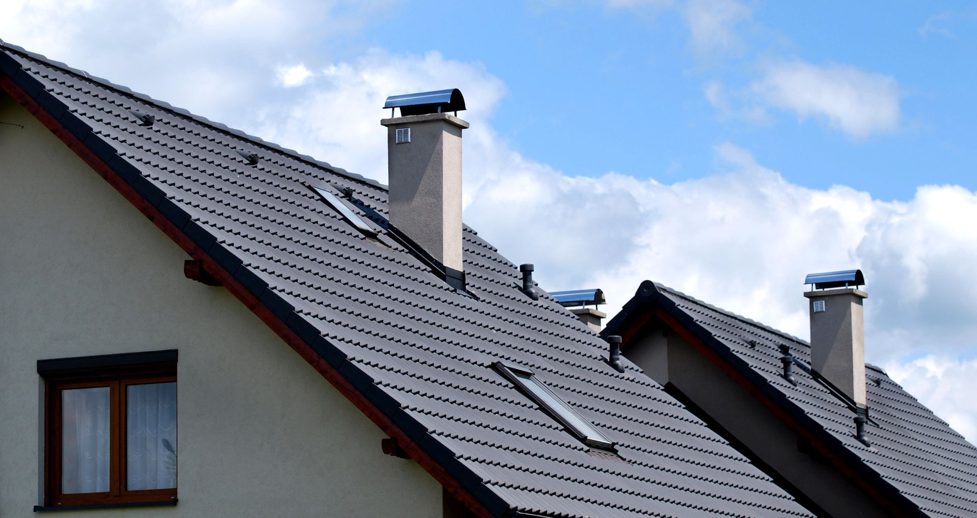 A row of houses with chimneys on their roofs