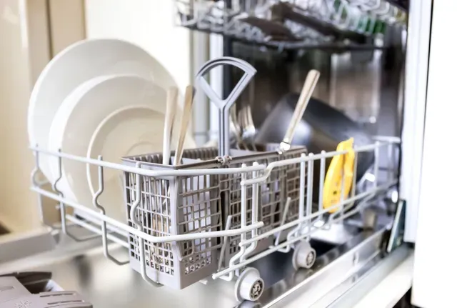 A dishwasher is filled with plates and utensils.