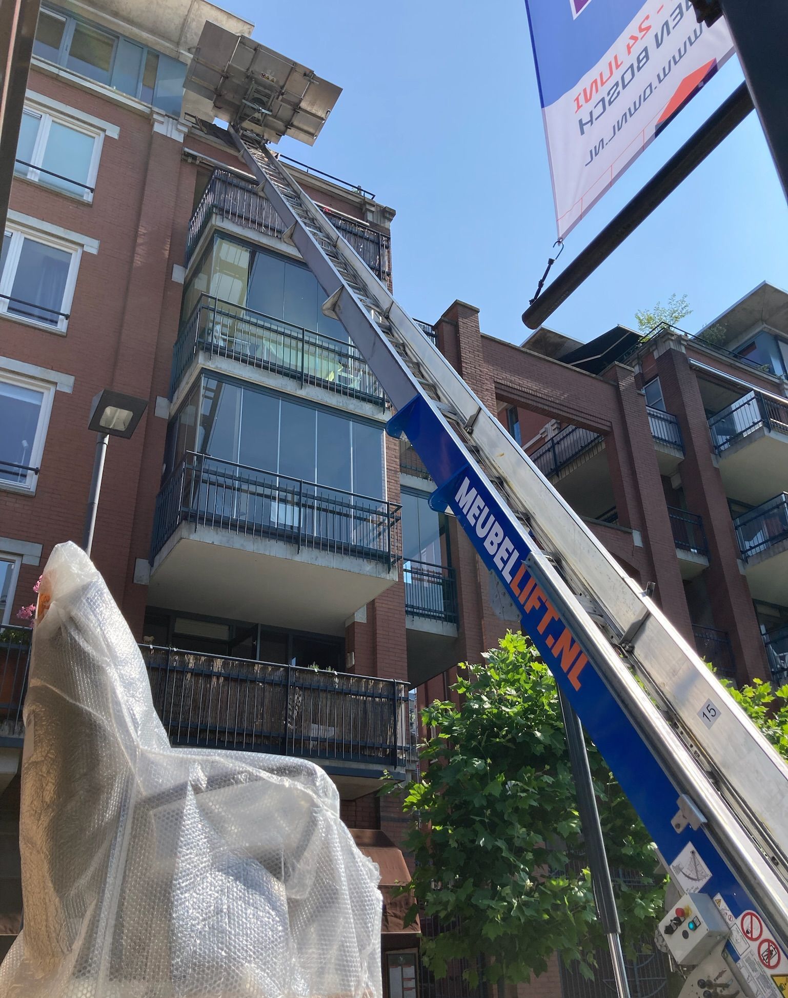 Een ladder wordt gebruikt om een standbeeld voor een gebouw te tillen.