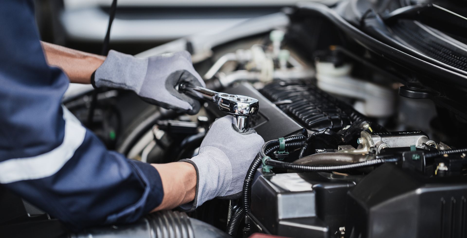 Professional mechanic working on the engine of the car in the garage.