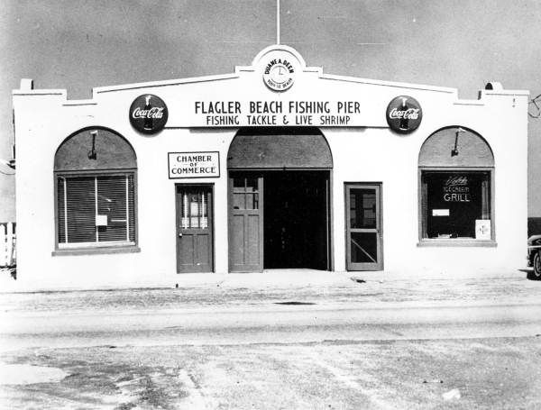 Black-and-white storefront of the Flagler Beach Fishing Pier ticket entrance with sign and windows