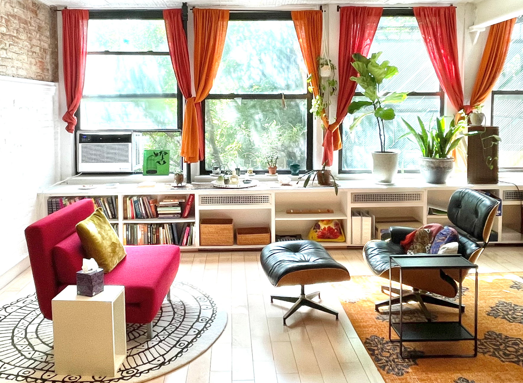 A living room with a red chair and a black chair
