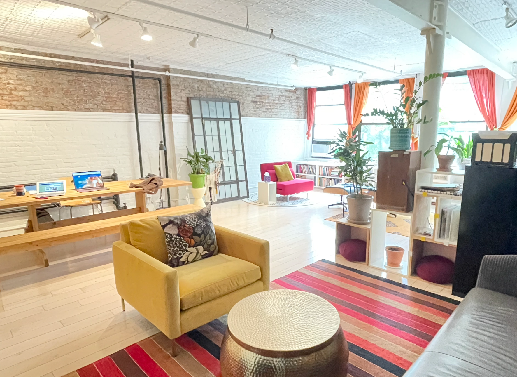 A living room with a yellow chair and a red couch.