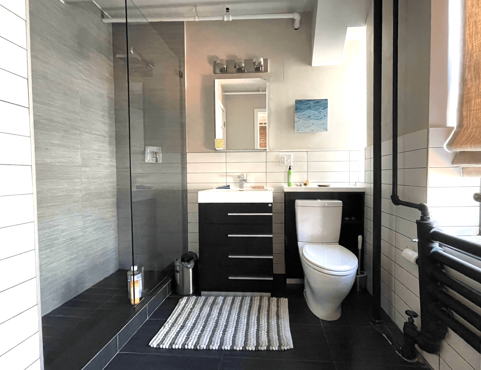 A bathroom with a toilet a sink and a walk in shower