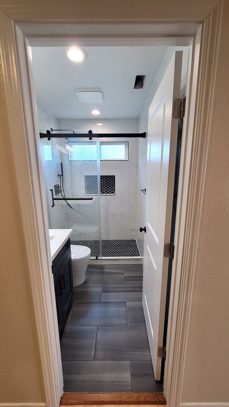 A bathroom with a sliding glass shower door and a toilet.
