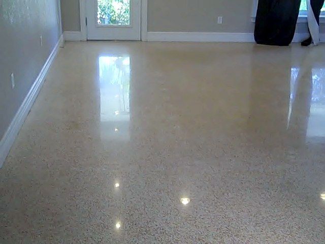 Polished concrete floor reflecting light in an empty room with a white door