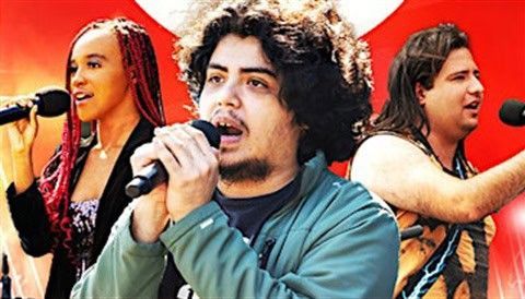 Three singers with microphones performing outdoors, brightly lit.