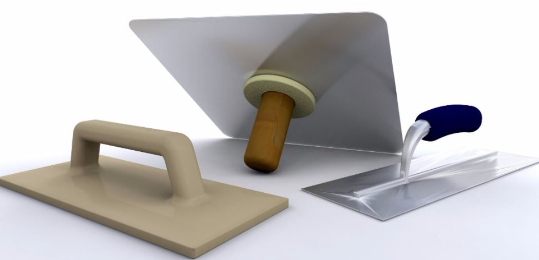 A trowel a spatula and a rolling pin on a white surface