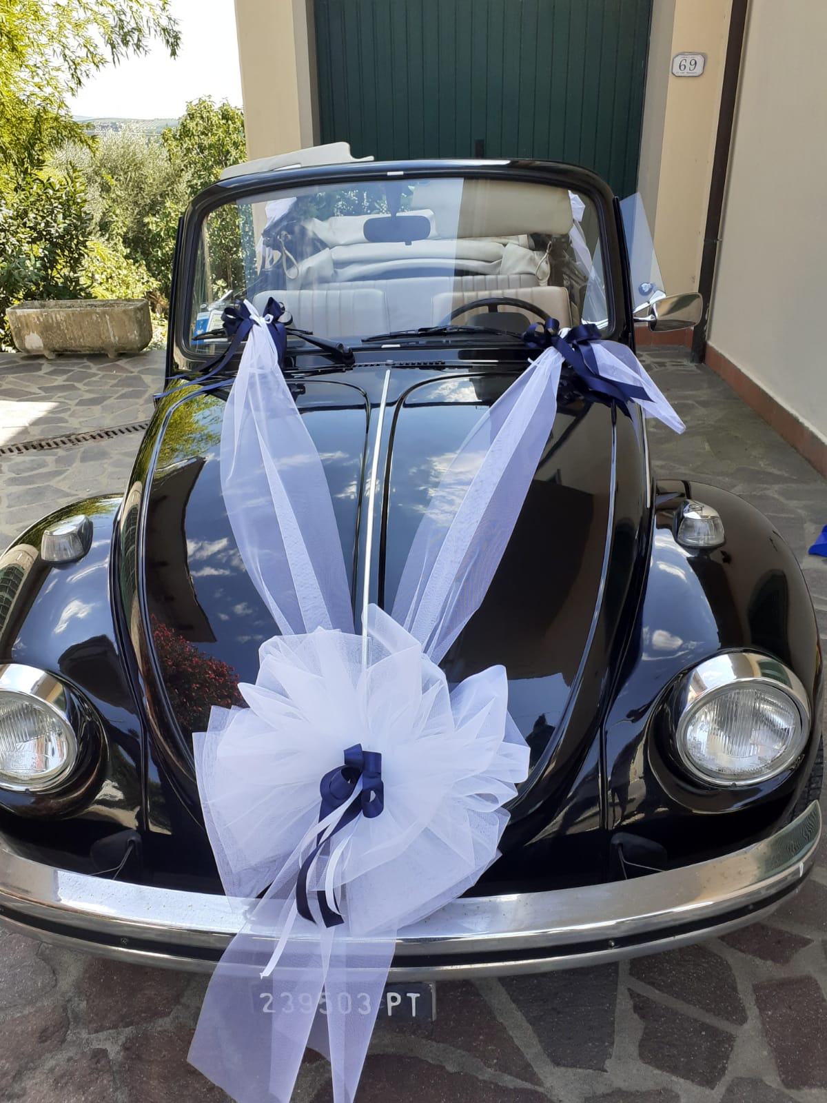 Maggiolino decappottabile d'epoca nero decorato con nastri bianchi e blu navy; targa italiana.