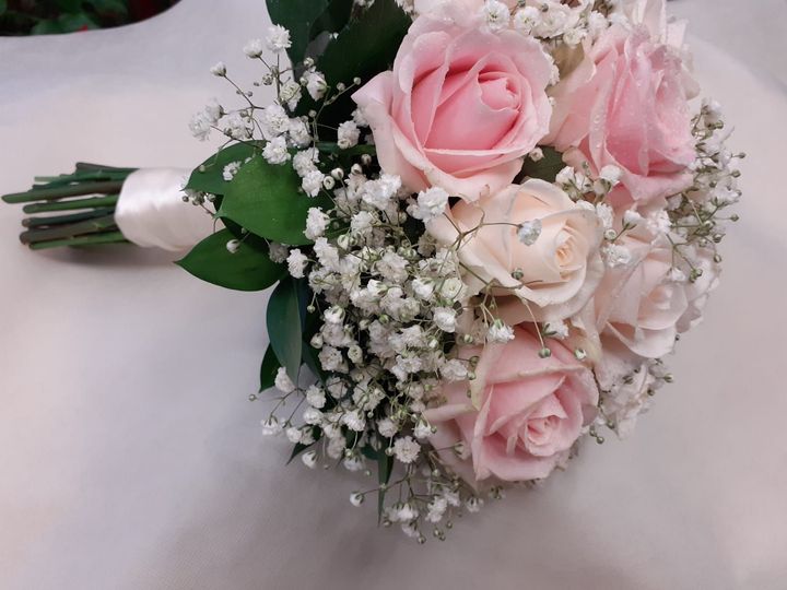 Bouquet di rose rosa e gypsophila bianchi, legati con un nastro color crema.