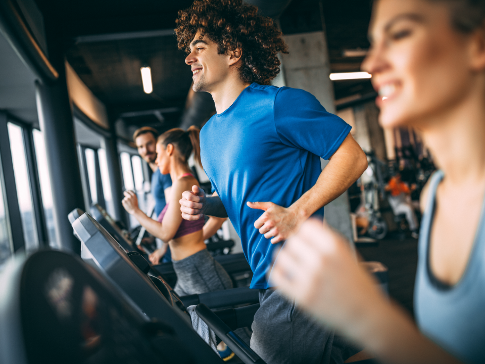 A group of people are running on treadmills in a gym.