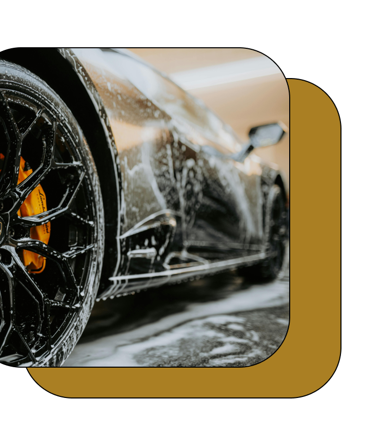 A black sports car is being washed with soap and water.