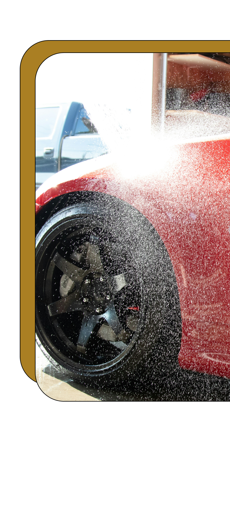 A red sports car is being washed with soap and water.