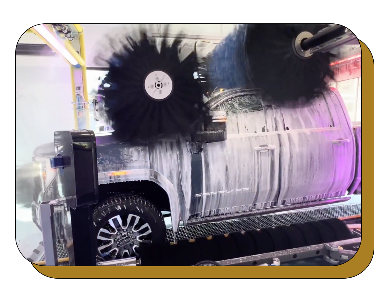 A truck is being cleaned by a machine in a car wash.