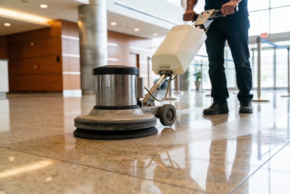 Person using a floor buffer on a polished lobby floor