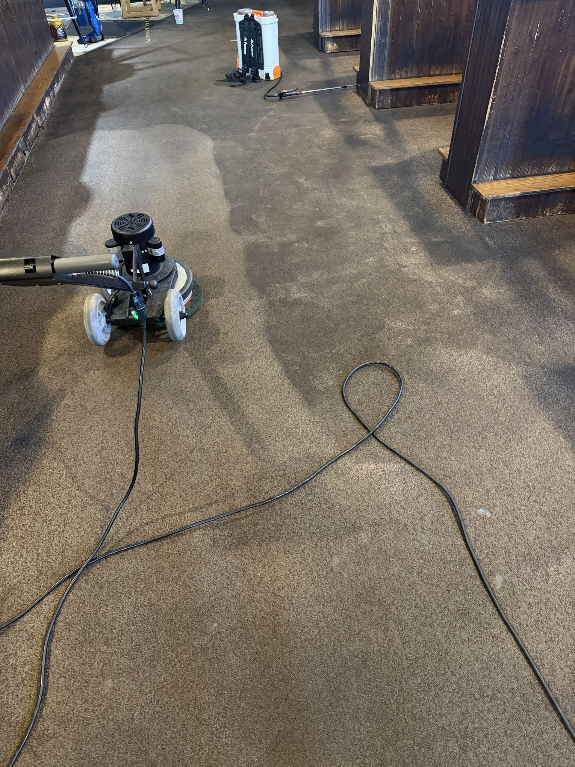 Two cords on a warehouse floor with a small machine in the background