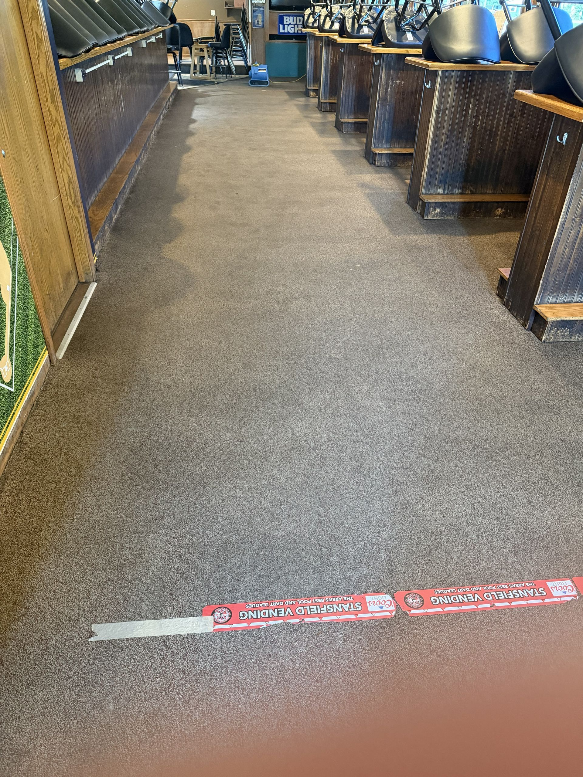 Indoor walkway with a red floor marker and counters on both sides, leading toward seating in the distance