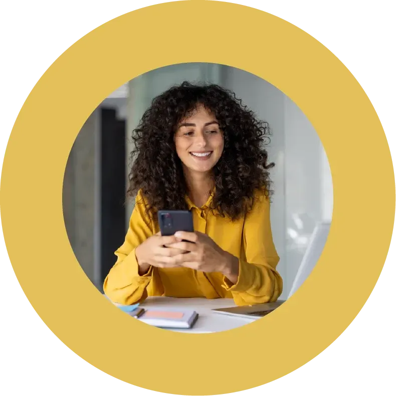 Beautiful smiling mixed race businesswoman dressed casual sitting in office and using phone.