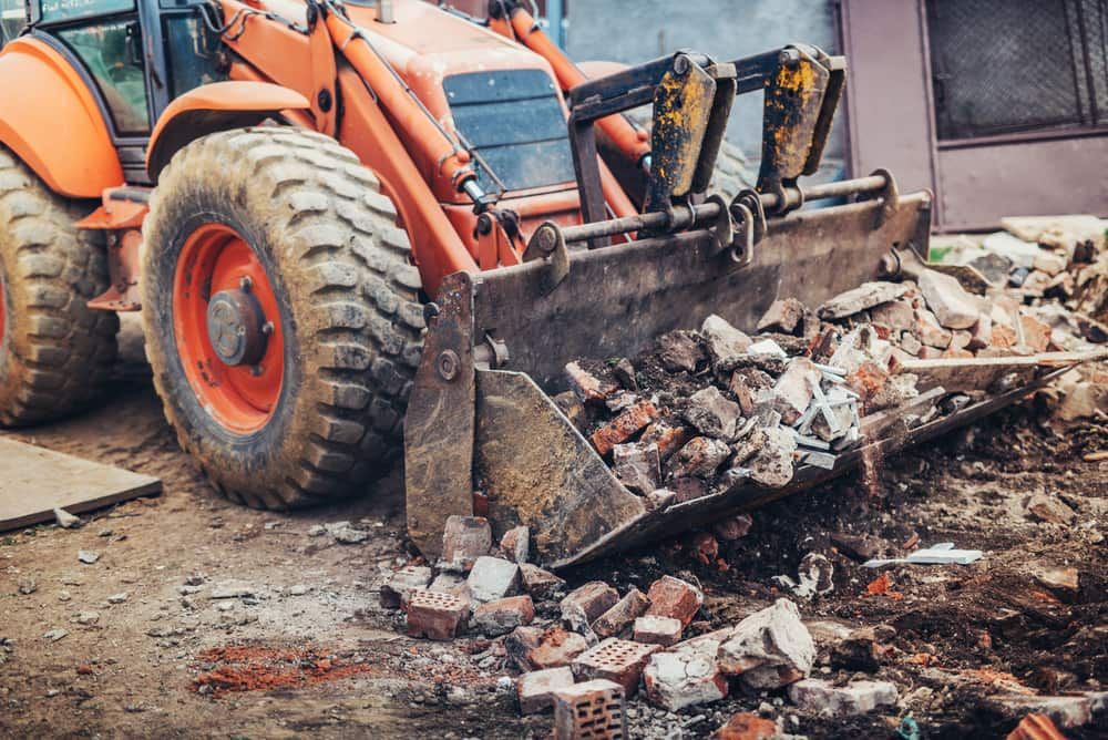 A Bulldozer is Moving Bricks on a Construction Site — Matt's Mini Machines in Rosemount, QLD
