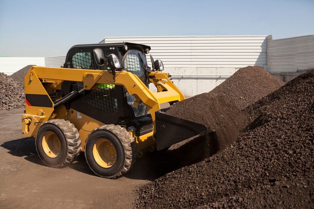 A Bulldozer is Scooping Dirt From a Pile of Dirt — Matt's Mini Machines in Palmwoods, QLD