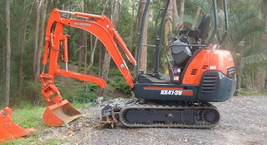 A Compact Orange Excavator Located on the Edge of a Road, Indicating Ongoing Construction Activities — Matt's Mini Machines in Bli Bli, QLD