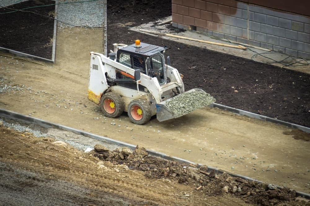 A Bulldozer is Moving Dirt on a Construction Site — Matt's Mini Machines in Yandina, QLD