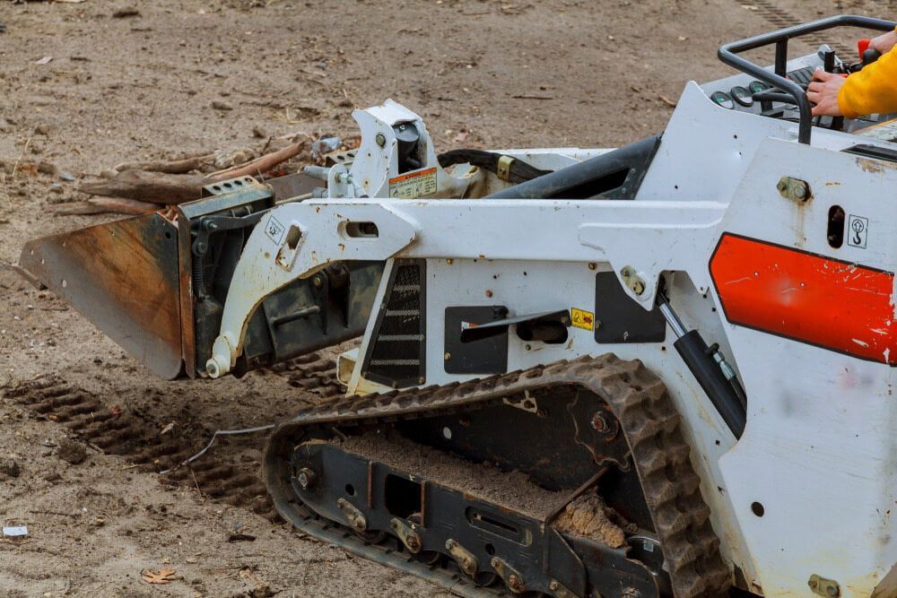 A Small Bulldozer is Sitting in the Dirt on a Construction Site — Matt's Mini Machines in Caloundra, QLD