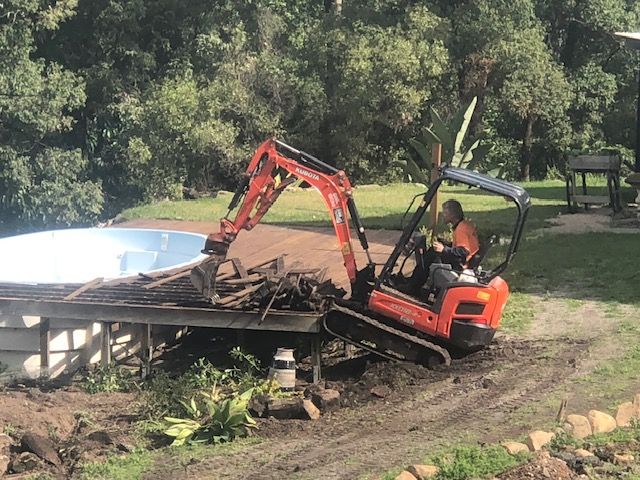 A Bulldozer is Moving a Pile of Rocks on a Road — Matt's Mini Machines in Bli Bli, QLD