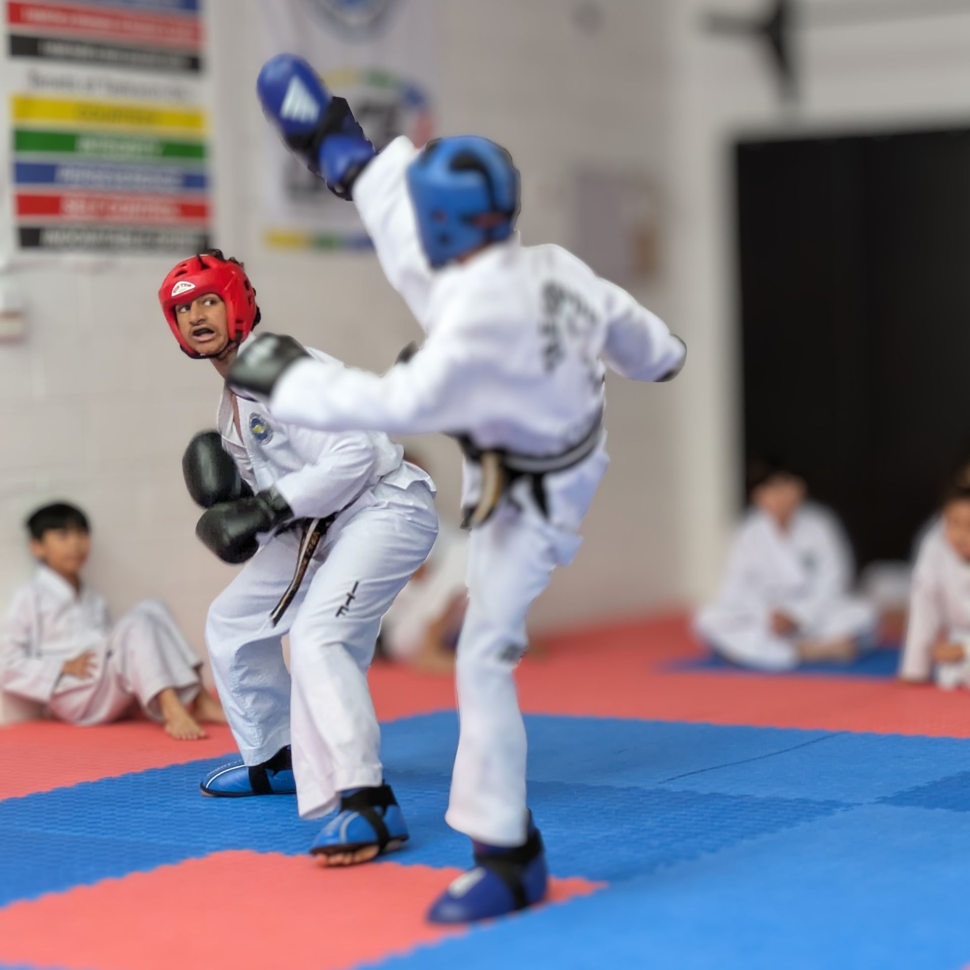 A man is guiding a woman during a taekwondo class.