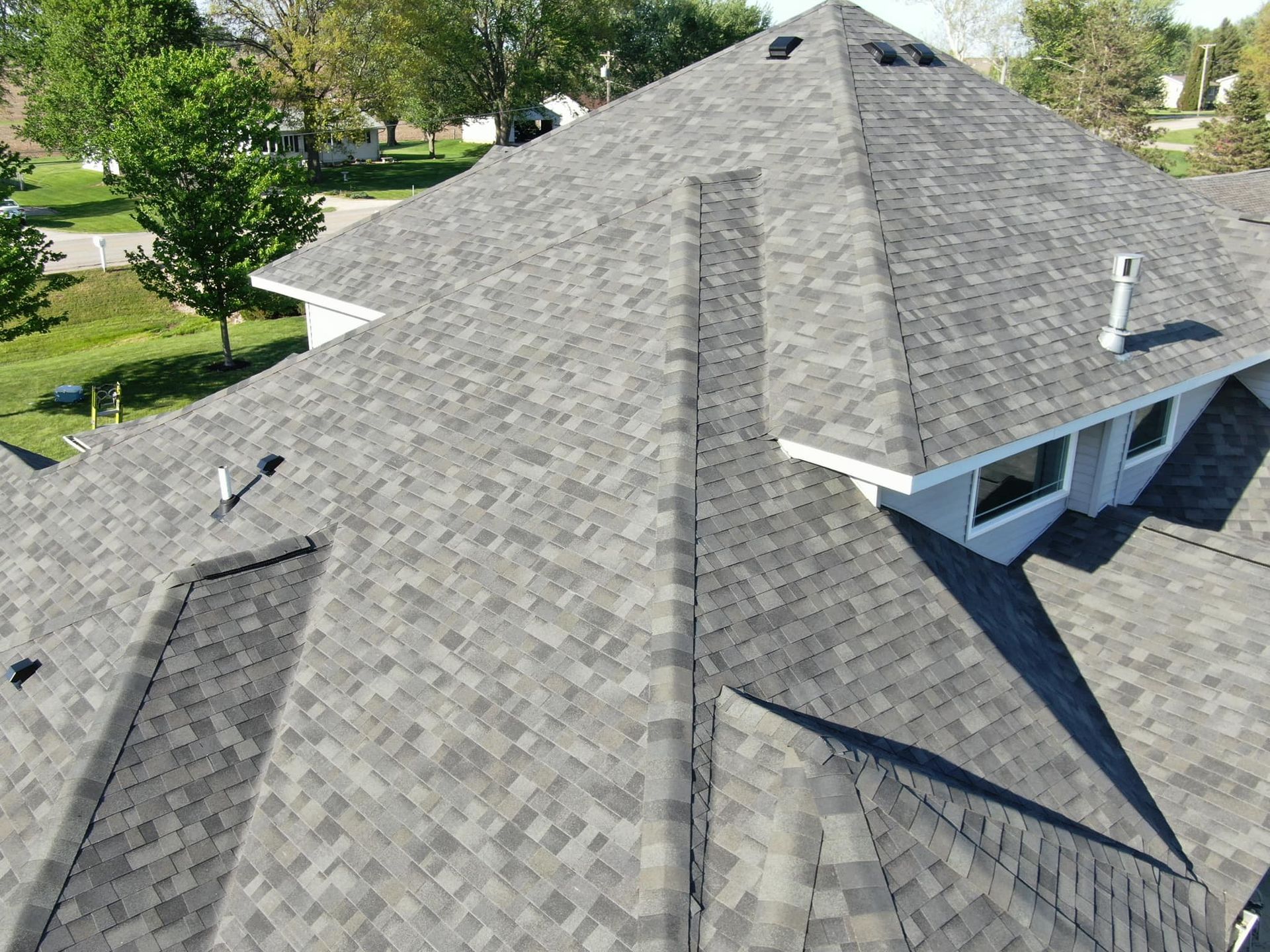 An aerial view of a house with a gray roof