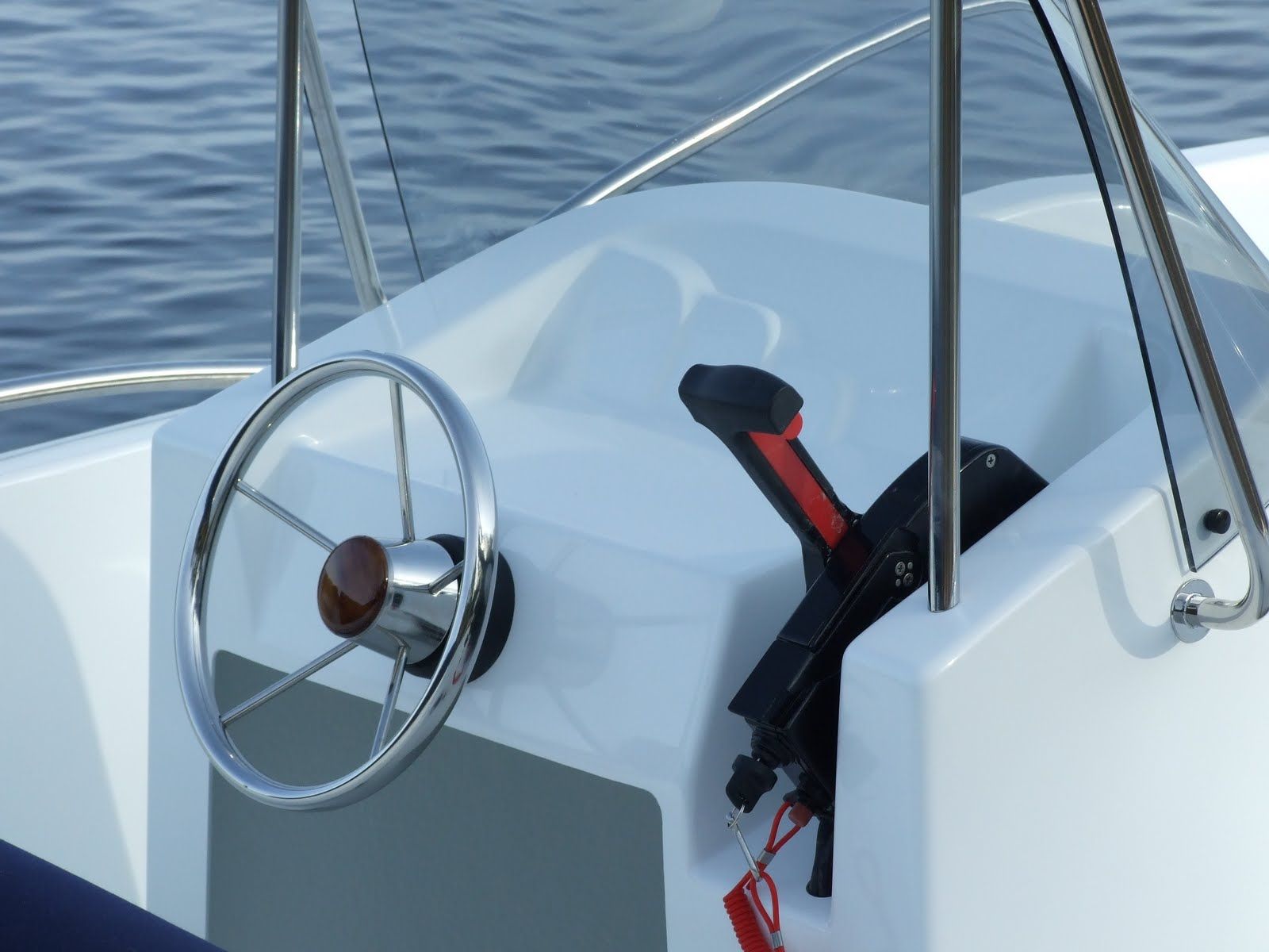 Een witte boot met een stuurwiel en een voorruit