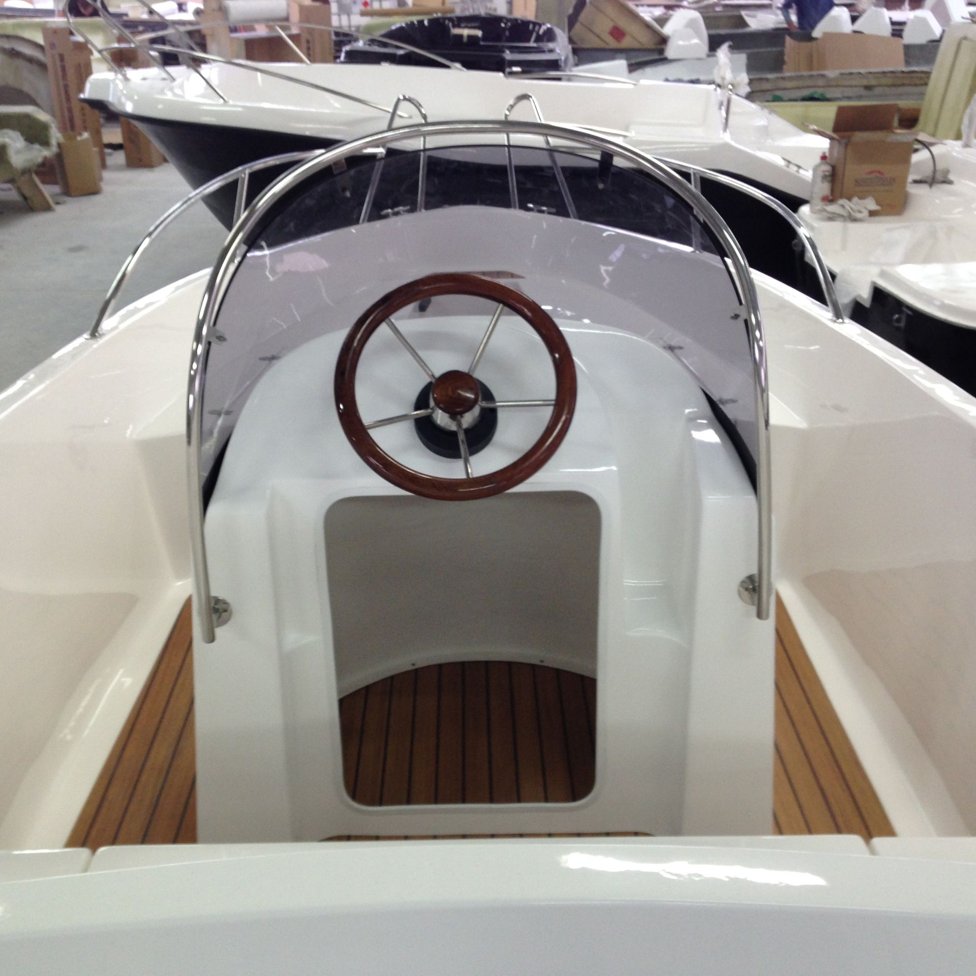 Een witte boot met een houten stuurwiel