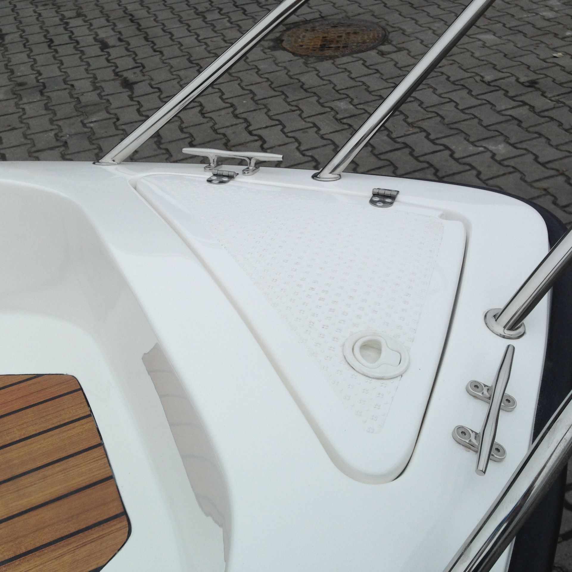 De achterkant van een witte boot met een houten dek