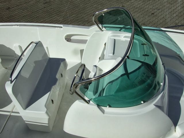 Een witte boot met een groene voorruit en stuurwiel