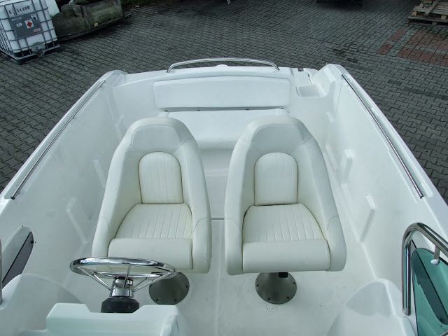 Een witte boot met twee witte stoelen en een stuurwiel