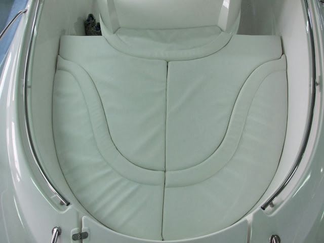 Een witte boot met een witte stoel en kussens