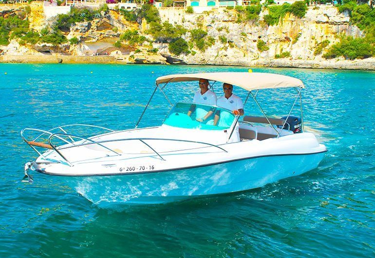 Twee mannen varen in een witte boot op de oceaan.