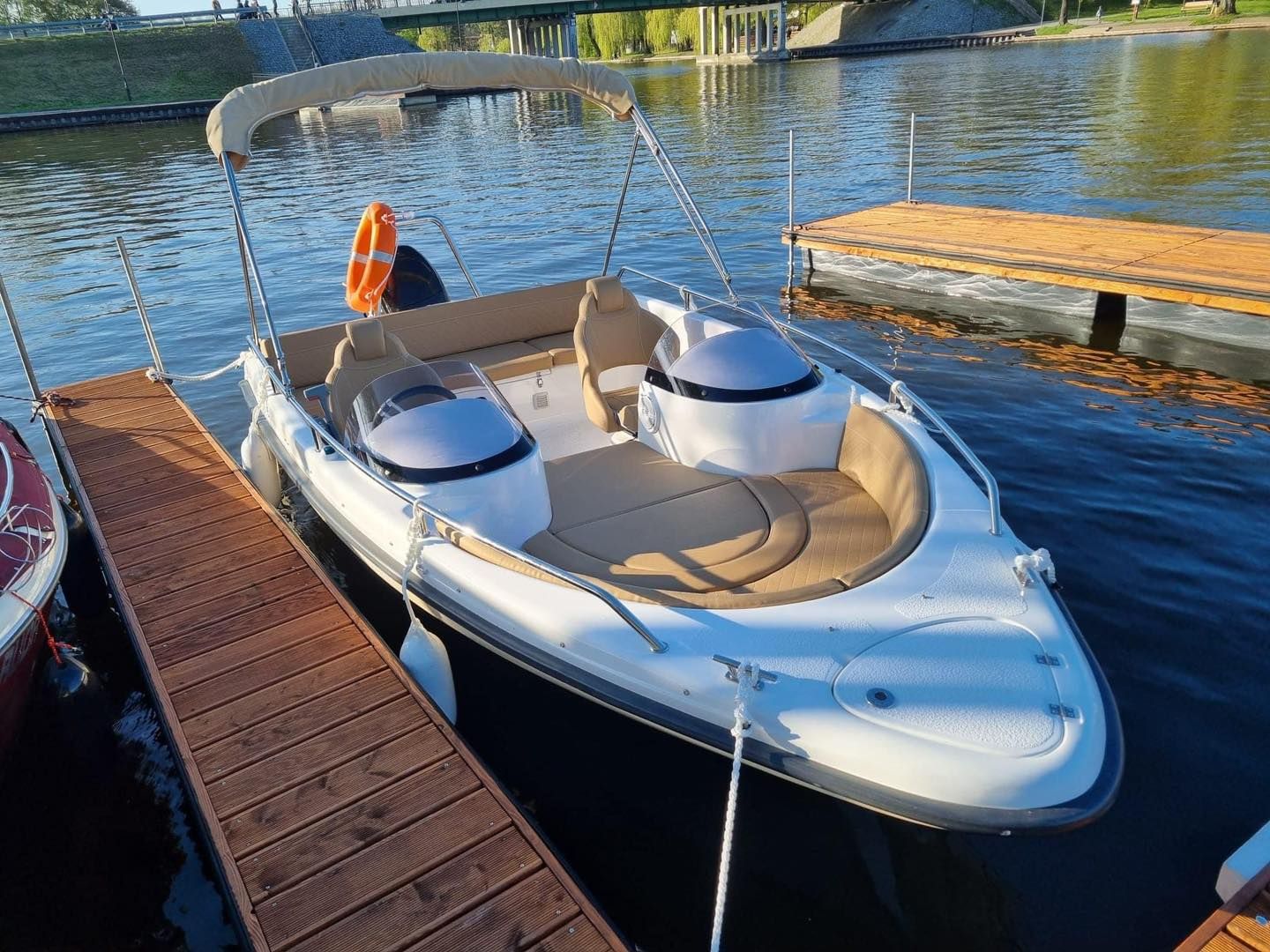 Een boot ligt aangemeerd aan een steiger op een meer.