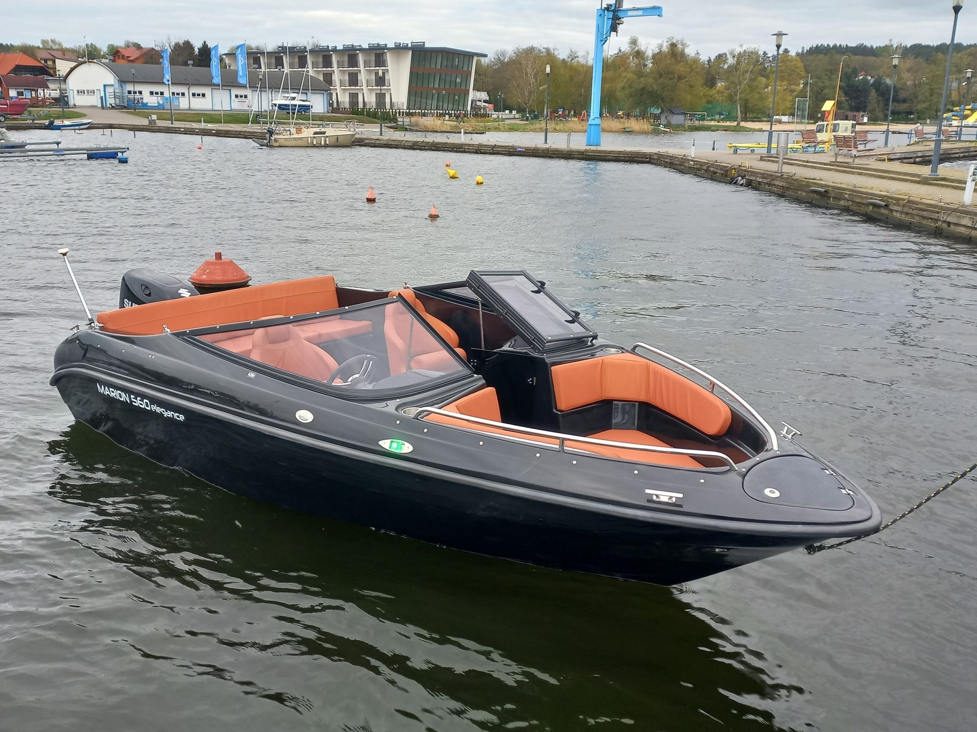 Een zwart-oranje boot drijft op een watermassa