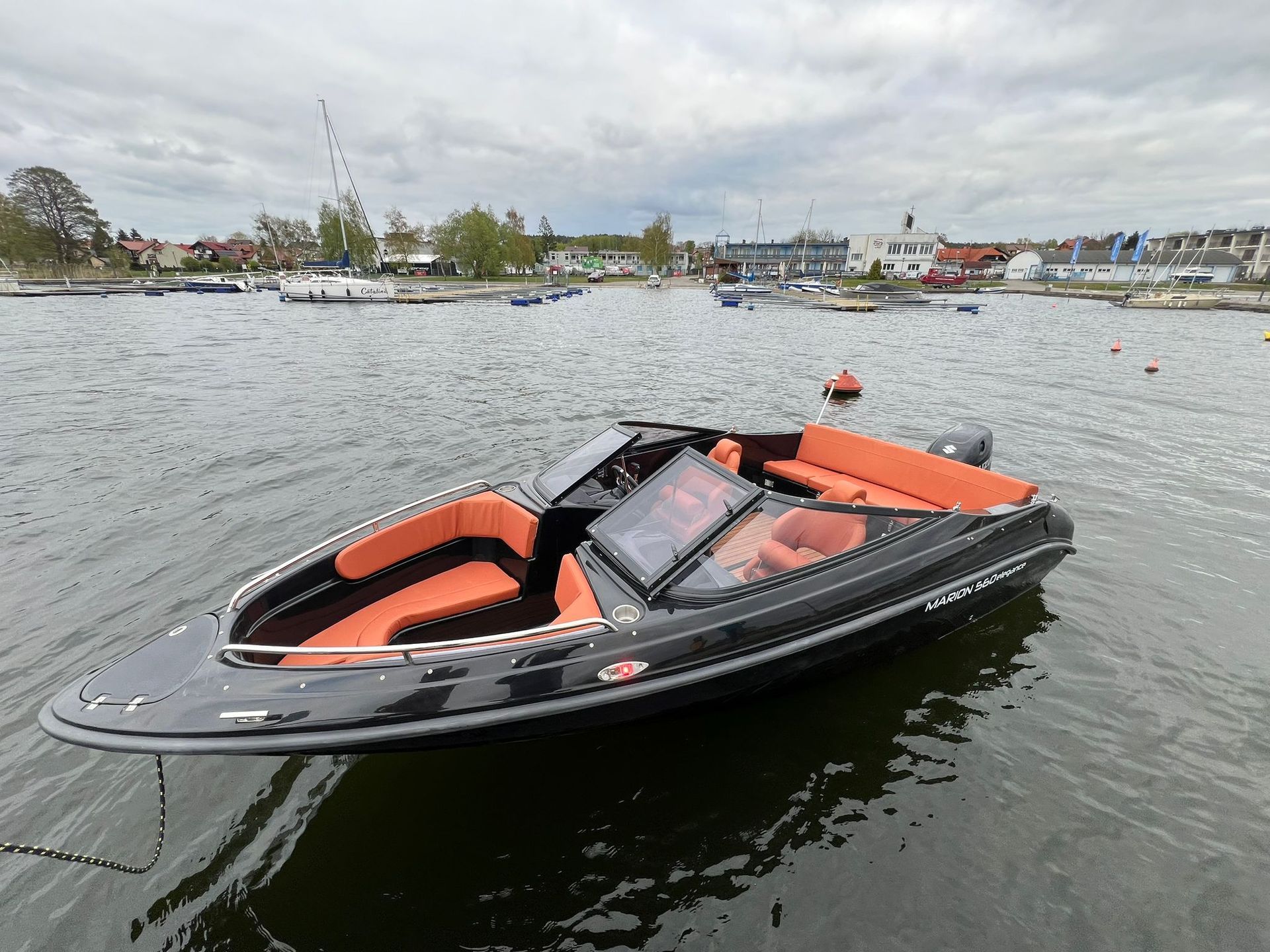 Een zwart-oranje boot drijft op een watermassa.
