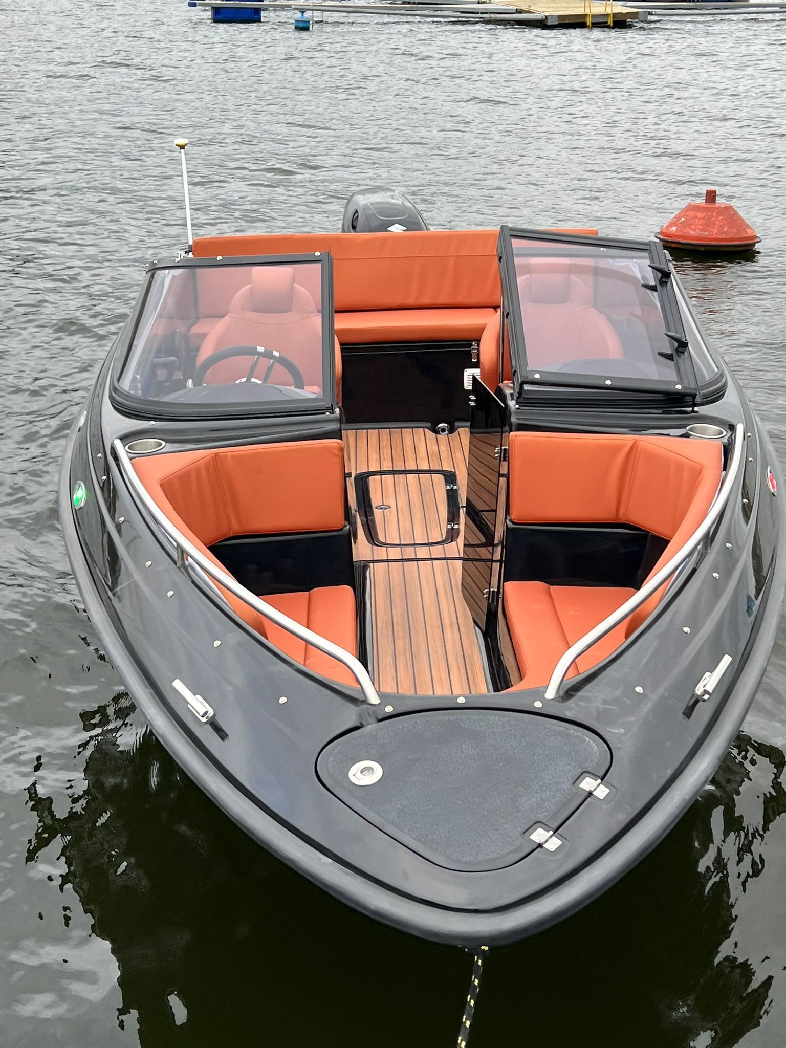 Een zwart-oranje boot drijft op een watermassa.