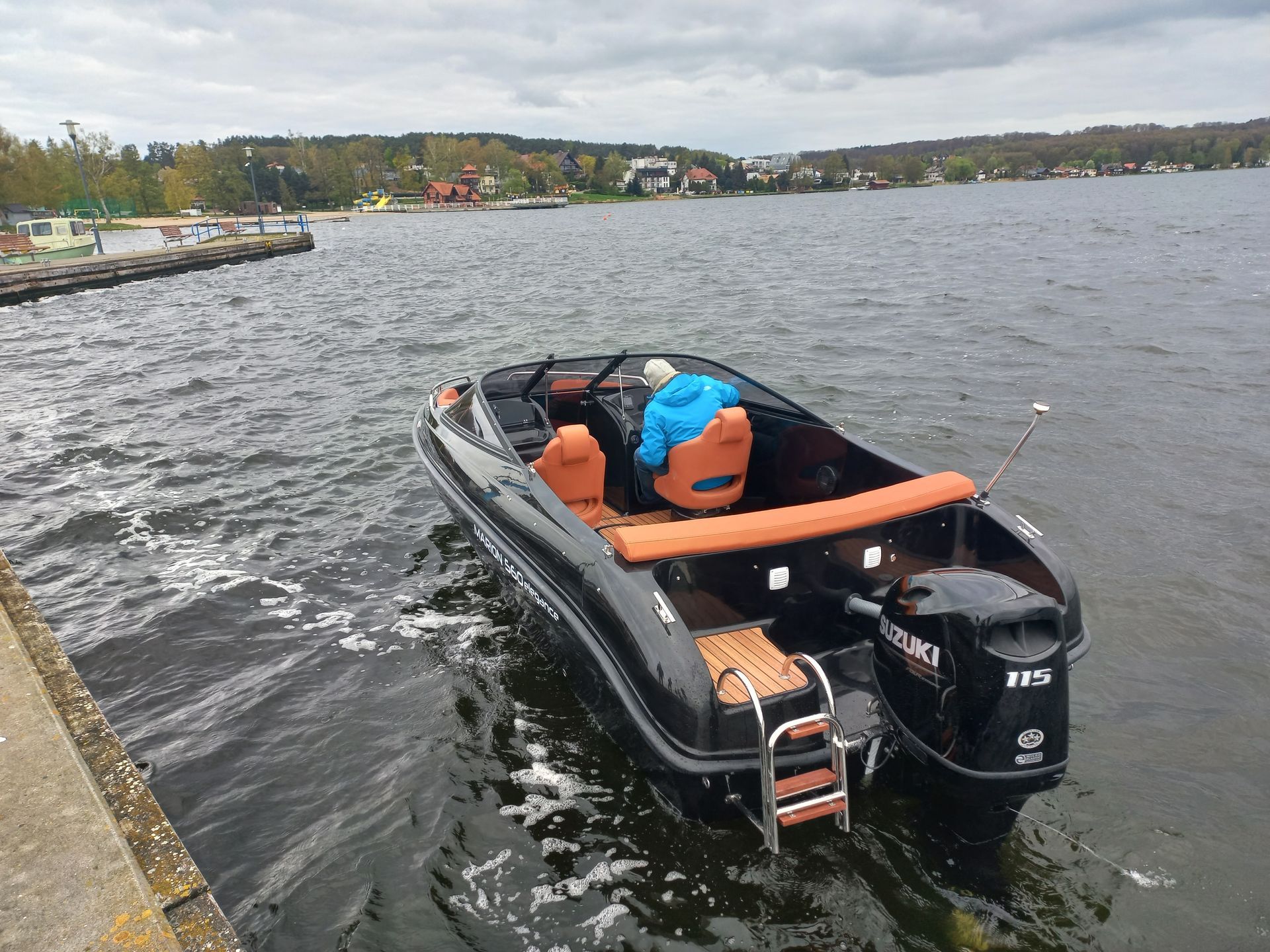 Een boot ligt aangemeerd aan een steiger op een meer.