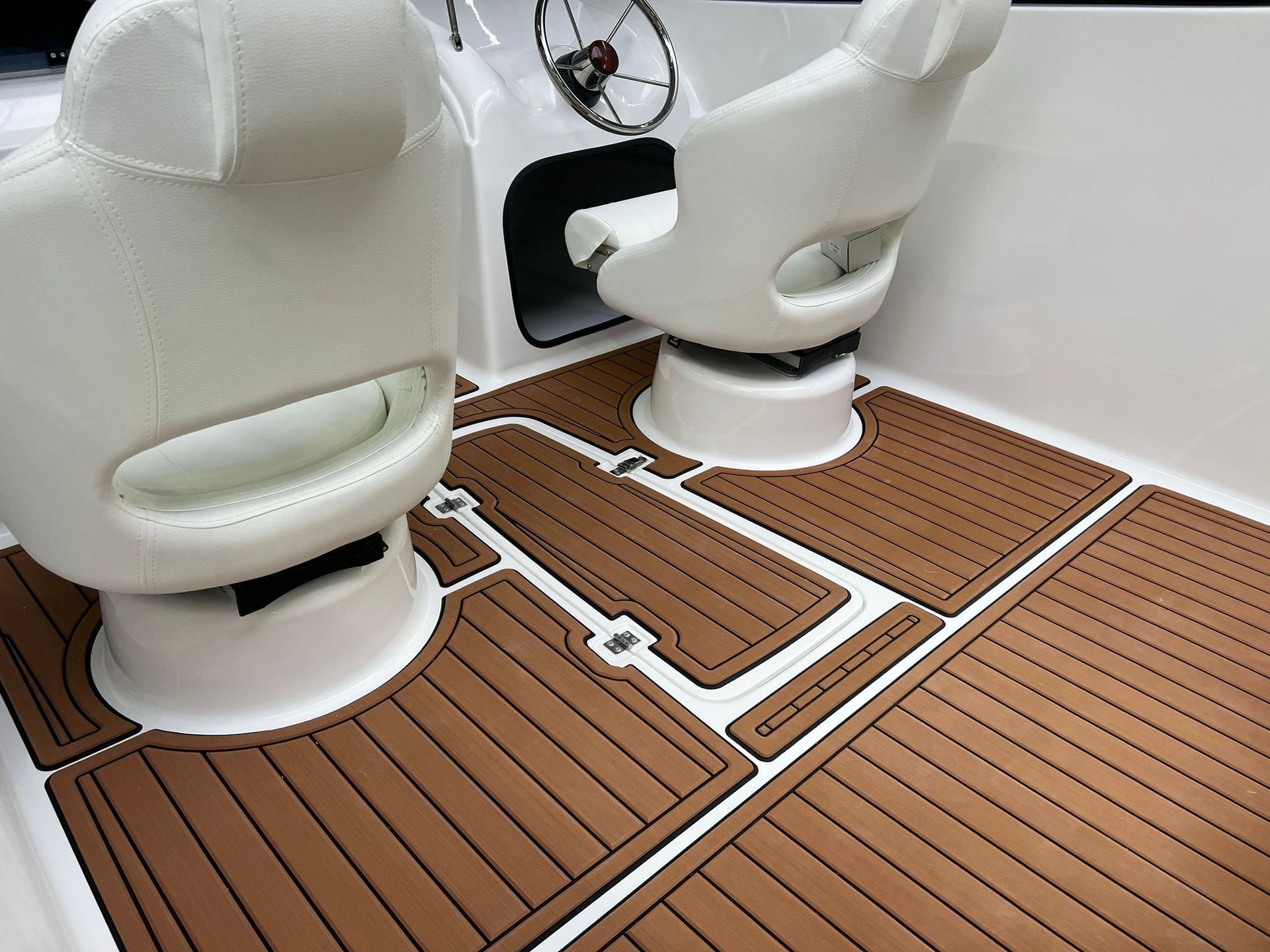 Een boot met een houten vloer en witte stoelen
