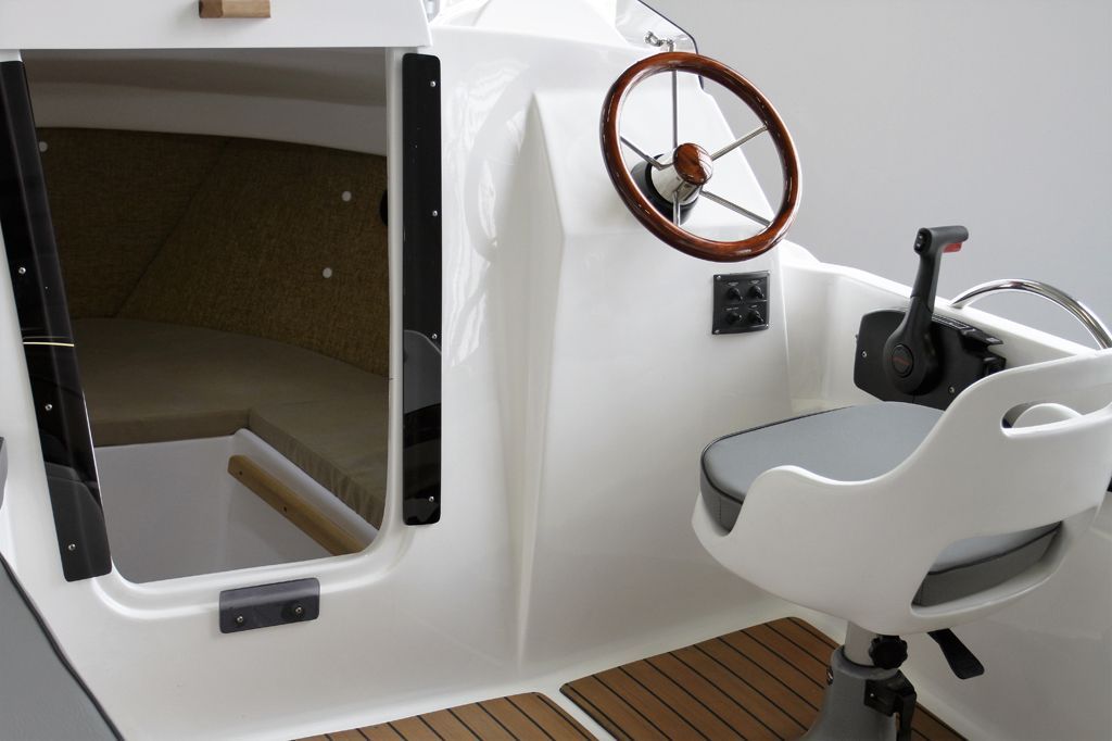 Een witte boot met een stuurwiel en een stoel