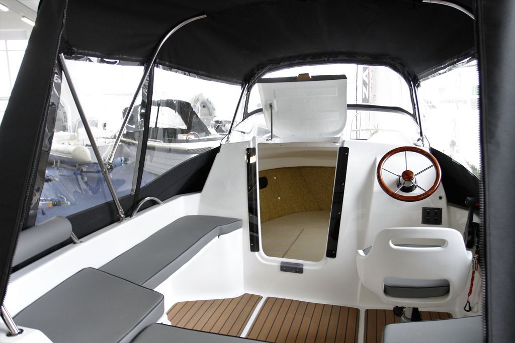 De binnenkant van een boot met een stuurwiel en een kap