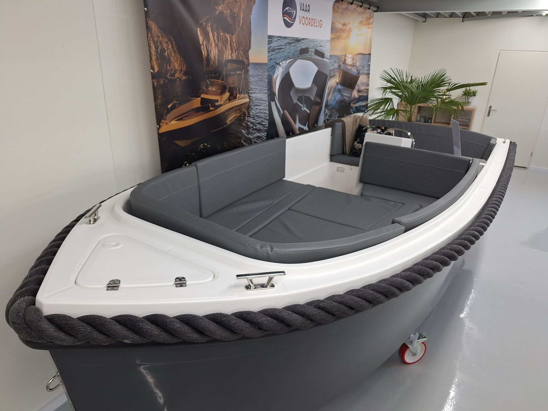 Een kleine boot ligt op een betonnen vloer in een kamer.