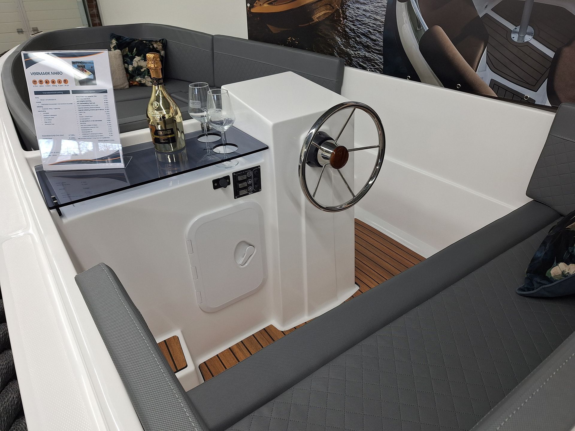 De binnenkant van een boot met een stuurwiel en een tafel.